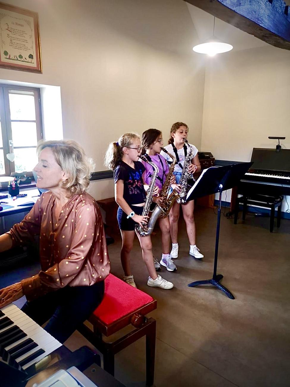 Cours de musique : trois élèves saxophonistes accompagnées au piano par leur professeure