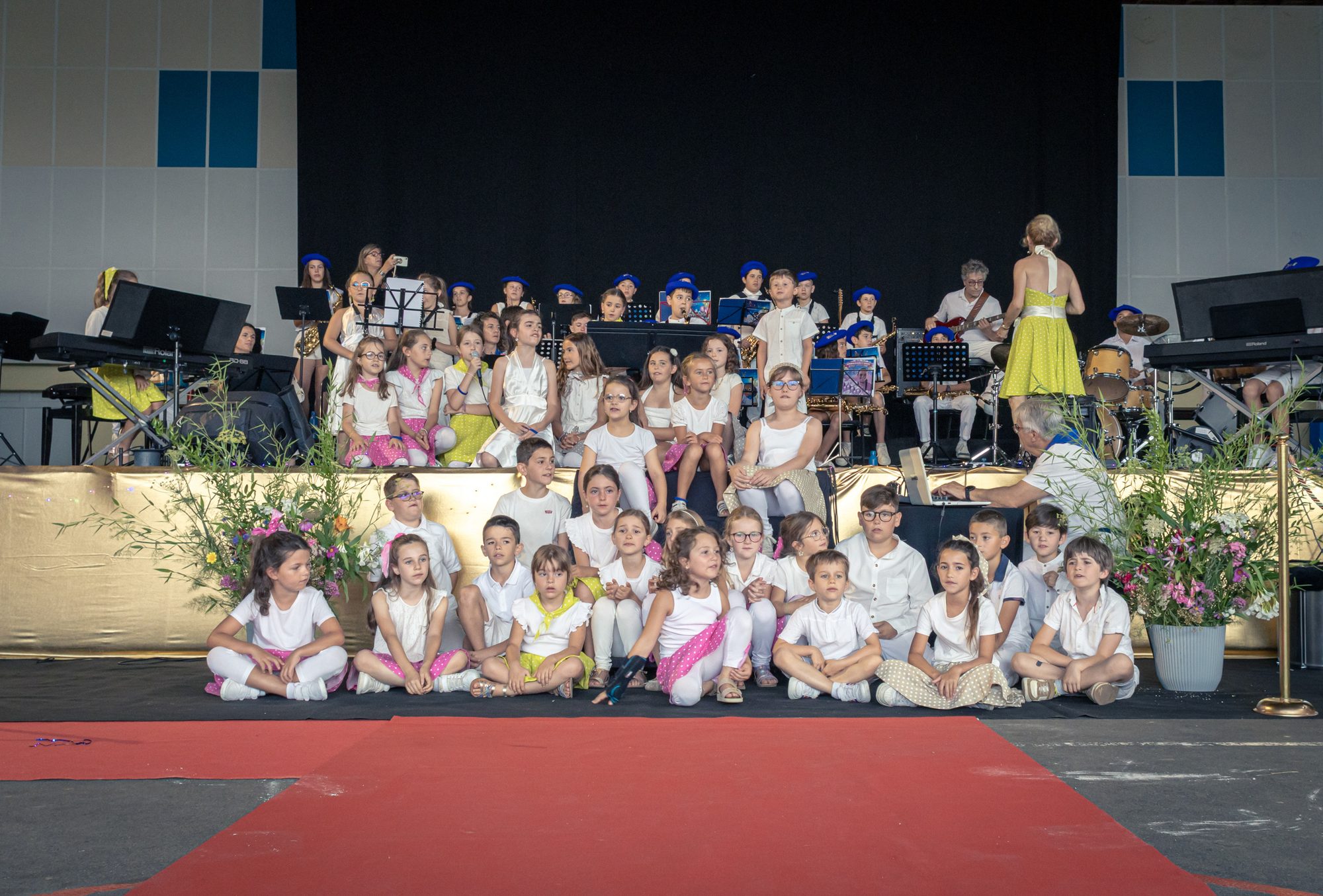 Les élèves de l'école de musique réunis sur le podium, les plus jeunes assis au premier rang